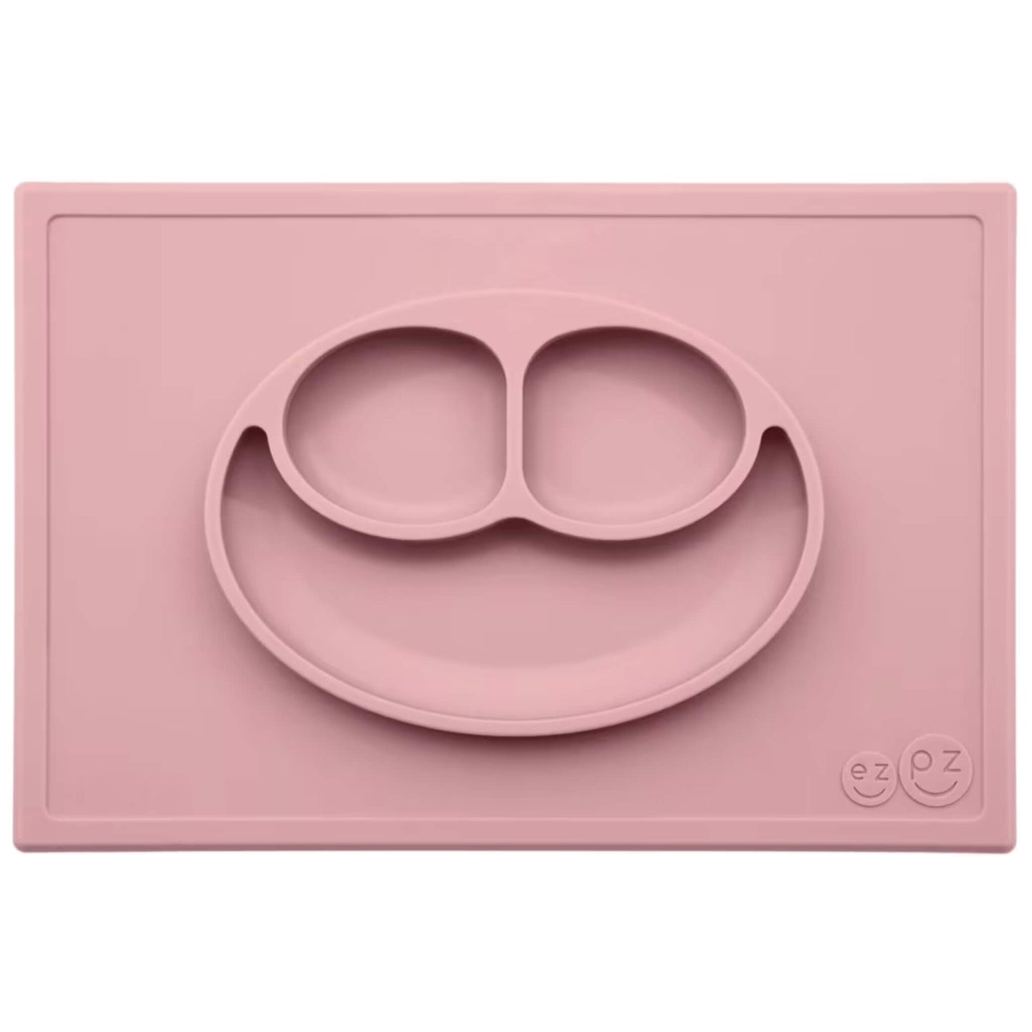 Ezpz Happy Mat in blush pink, a silicone placemat and plate in one with three compartments in a smiley face design to make toddler mealtimes easier.