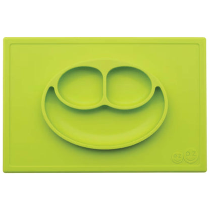 Ezpz Happy Mat in lime green, a silicone placemat and plate in one with three compartments in a smiley face design for toddler mealtimes.