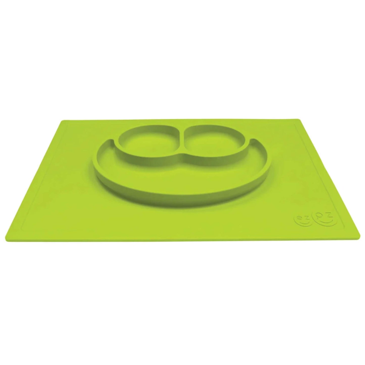 A lime green silicone placemat and plate shown from an angle, with three integrated compartments shaped like a smiley face.
