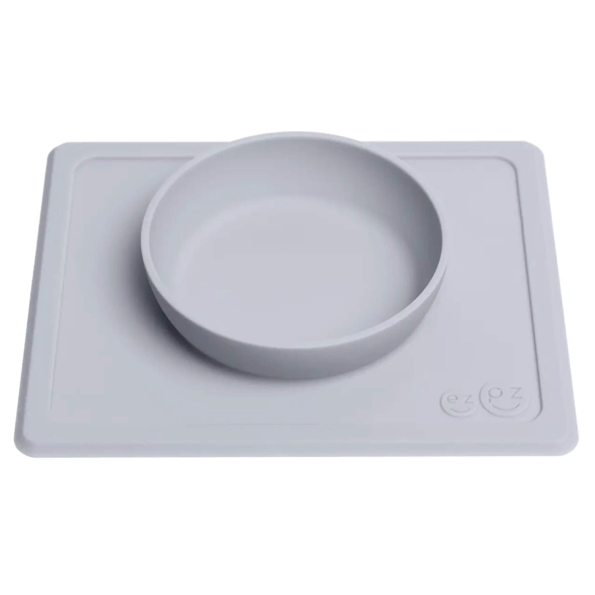 Grey silicone suction placemat with integrated feeding bowl designed to stay in place on the table during baby and toddler meals.
