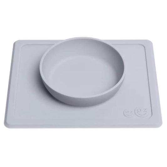Grey silicone suction placemat with integrated feeding bowl designed to stay in place on the table during baby and toddler meals.