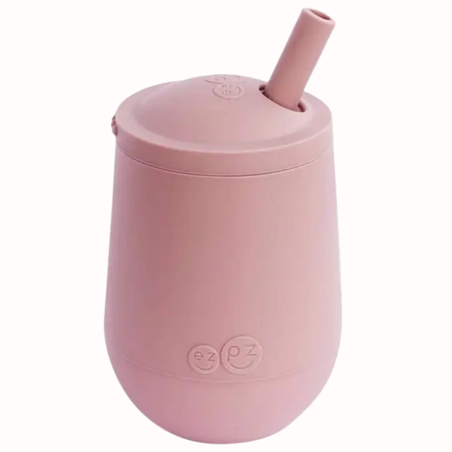 Blush silicone mini cup with angled straw lid designed to help toddlers learn open cup and straw drinking.