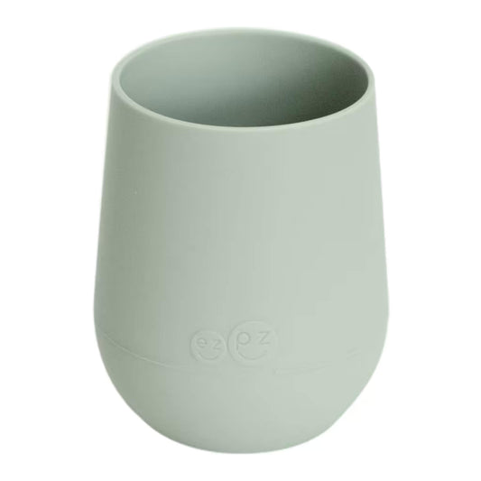 Ezpz Mini Cup in sage green, made from soft silicone with a non-slip base, designed as a toddler training cup for open cup drinking.