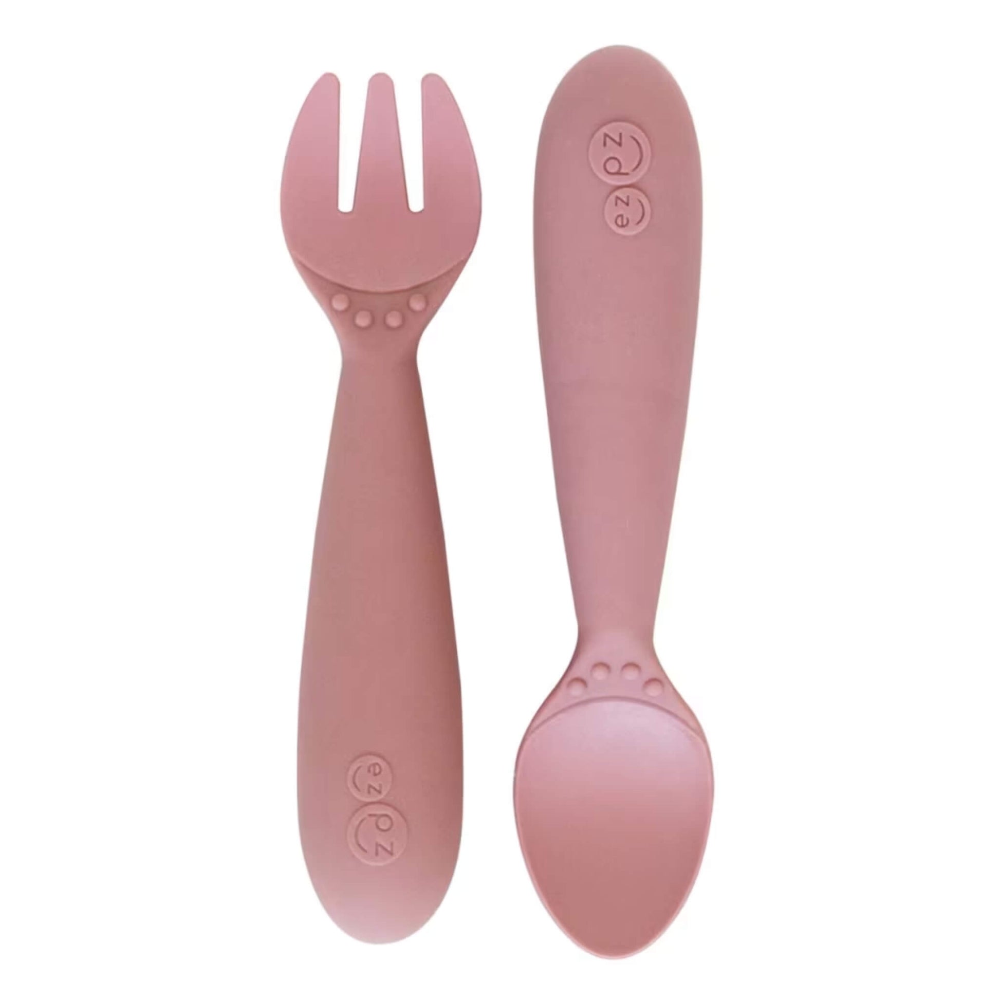 Ezpz Mini Utensils in Blush, a silicone toddler fork and spoon set with rounded handles for safe self-feeding.