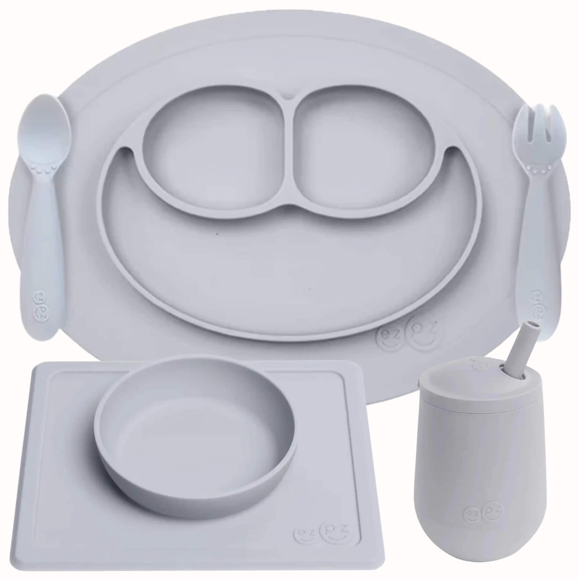 ezpz Self-Feeding Mealtime Bundle in pewter featuring a silicone mini mat with spoon and fork, suction bowl with placemat and mini cup with straw.
