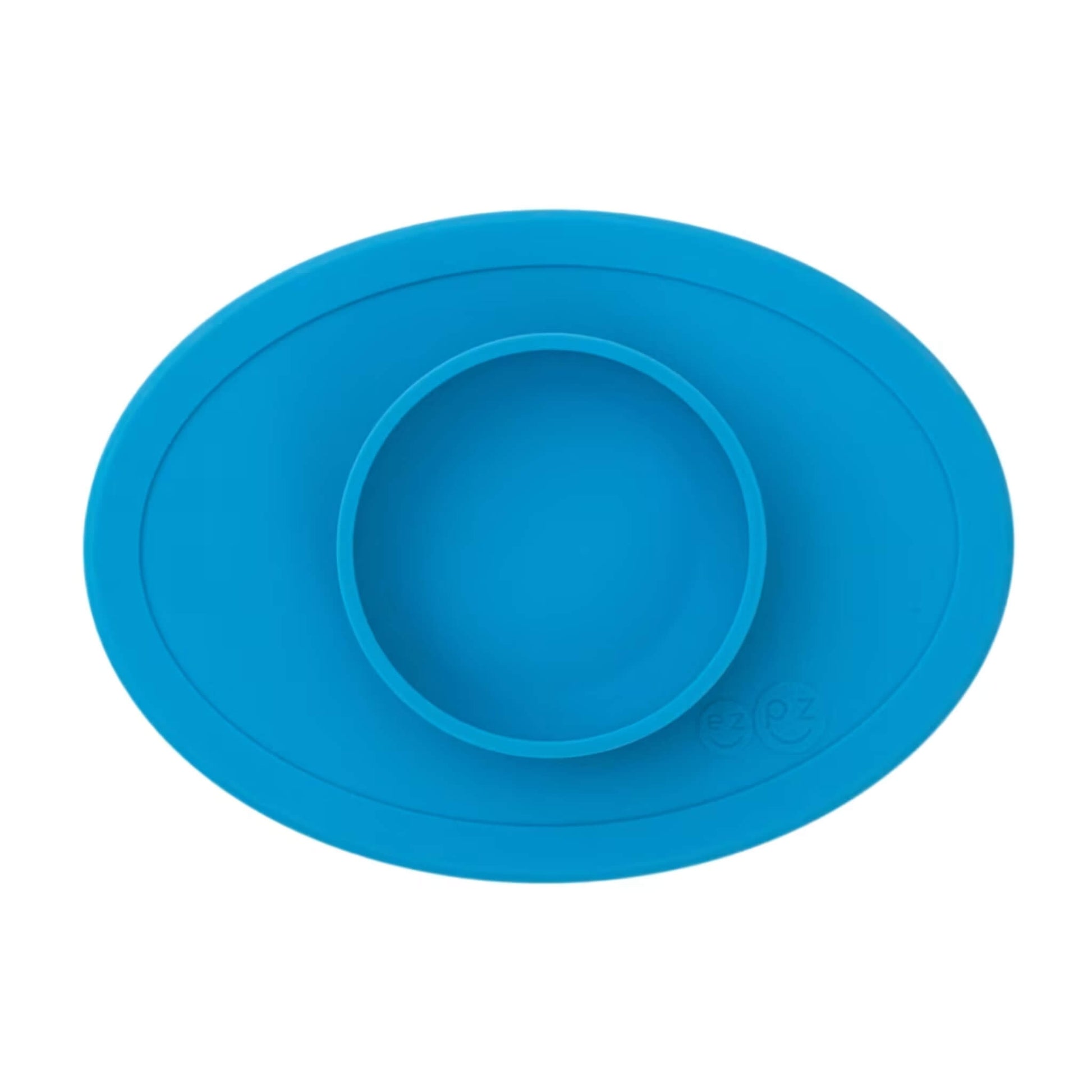 ezpz Tiny Bowl in blue. An oval silicone placemat with a small round bowl built into the centre, designed for first foods and weaning.