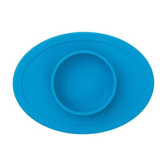 ezpz Tiny Bowl in blue. An oval silicone placemat with a small round bowl built into the centre, designed for first foods and weaning.