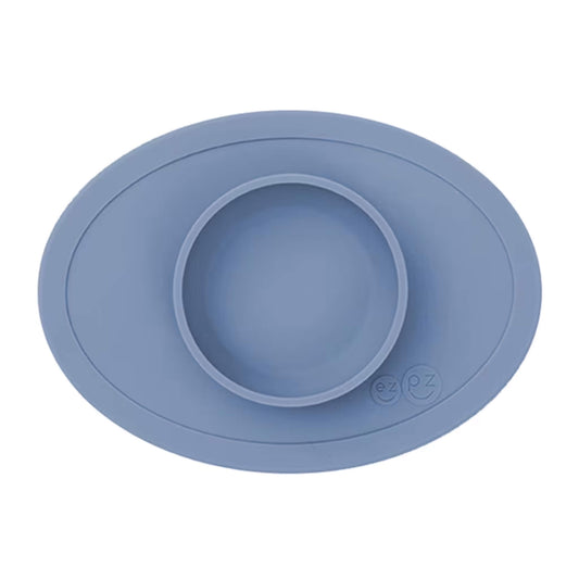 Ezpz Tiny Bowl in indigo, a silicone suction placemat with a built-in round bowl, shown empty against a plain background.