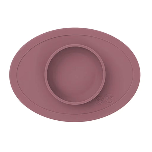 Ezpz Tiny Bowl in mauve, a silicone suction placemat with a built-in round bowl, shown empty against a plain background.