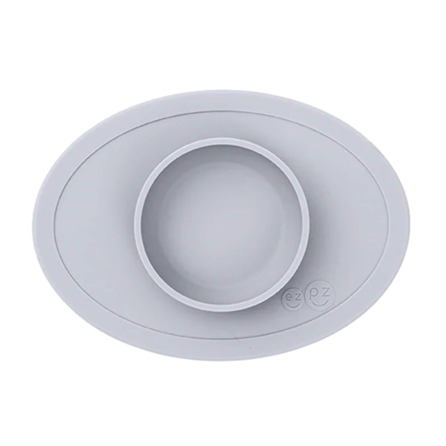 ezpz Tiny Bowl in pewter. An oval silicone placemat with a small round bowl built into the centre, designed for baby weaning and first foods.