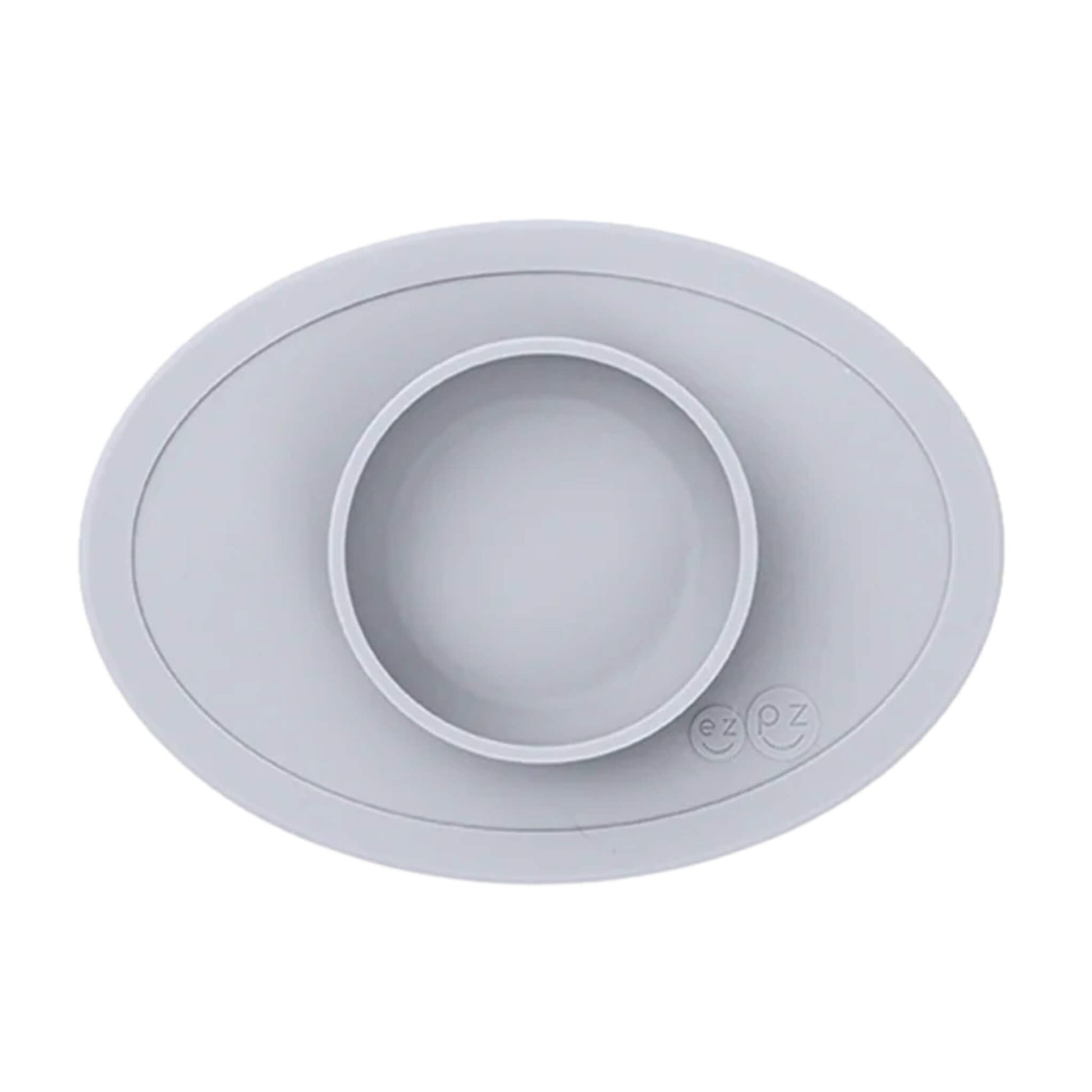 ezpz Tiny Bowl in pewter. An oval silicone placemat with a small round bowl built into the centre, designed for baby weaning and first foods.
