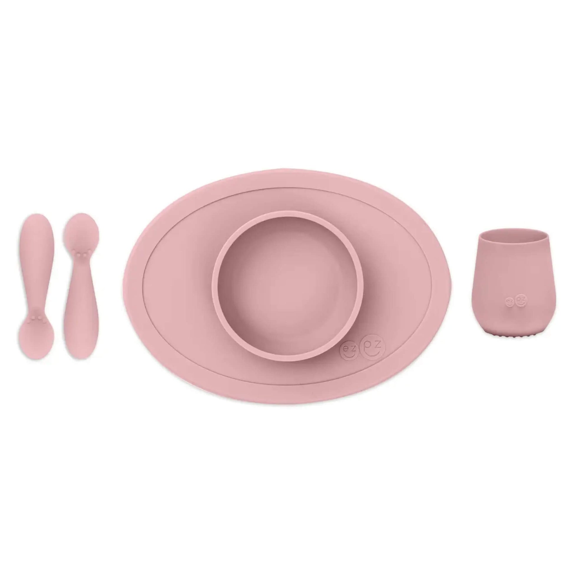 ezpz Tiny First Foods Set in Blush with silicone suction placemat, bowl, cup and two tiny spoons.