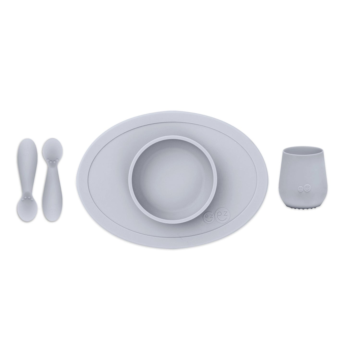 ezpz Tiny First Foods Set in pewter grey featuring a suction bowl, open cup and two soft silicone spoons for babies learning to self-feed.