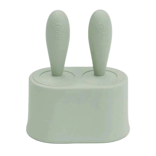 Ezpz Tiny Pops baby popsicle mould set in sage silicone with two freezer mould handles inserted into compact silicone base.