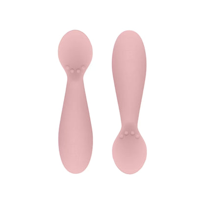 Ezpz Tiny Spoons in blush pink, a pair of silicone infant training spoons with shallow heads and textured bumps near the base.