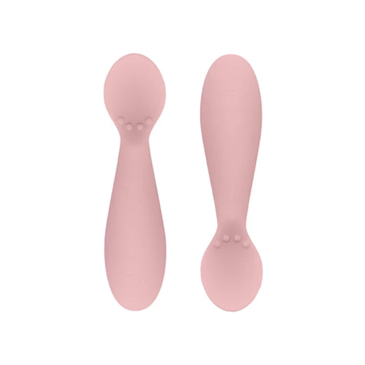 Ezpz Tiny Spoons in blush pink, a pair of silicone infant training spoons with shallow heads and textured bumps near the base.