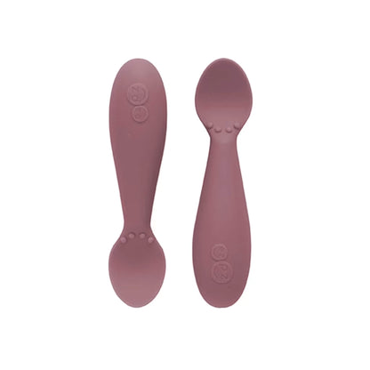 Ezpz Tiny Spoons in mauve, a pair of silicone infant training spoons with shallow heads and textured bumps near the base.