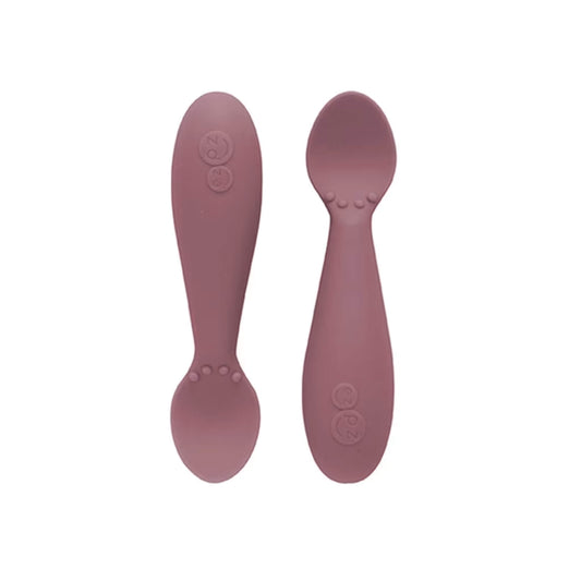 Ezpz Tiny Spoons in mauve, a pair of silicone infant training spoons with shallow heads and textured bumps near the base.