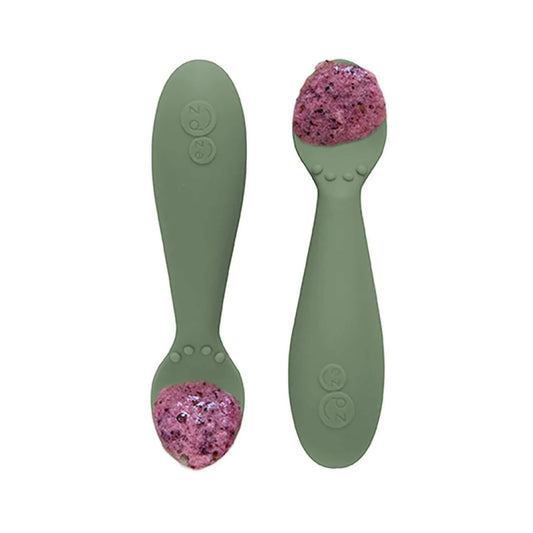 Pair of olive green silicone training spoons, each filled with a serving of purple baby food, shown close-up.