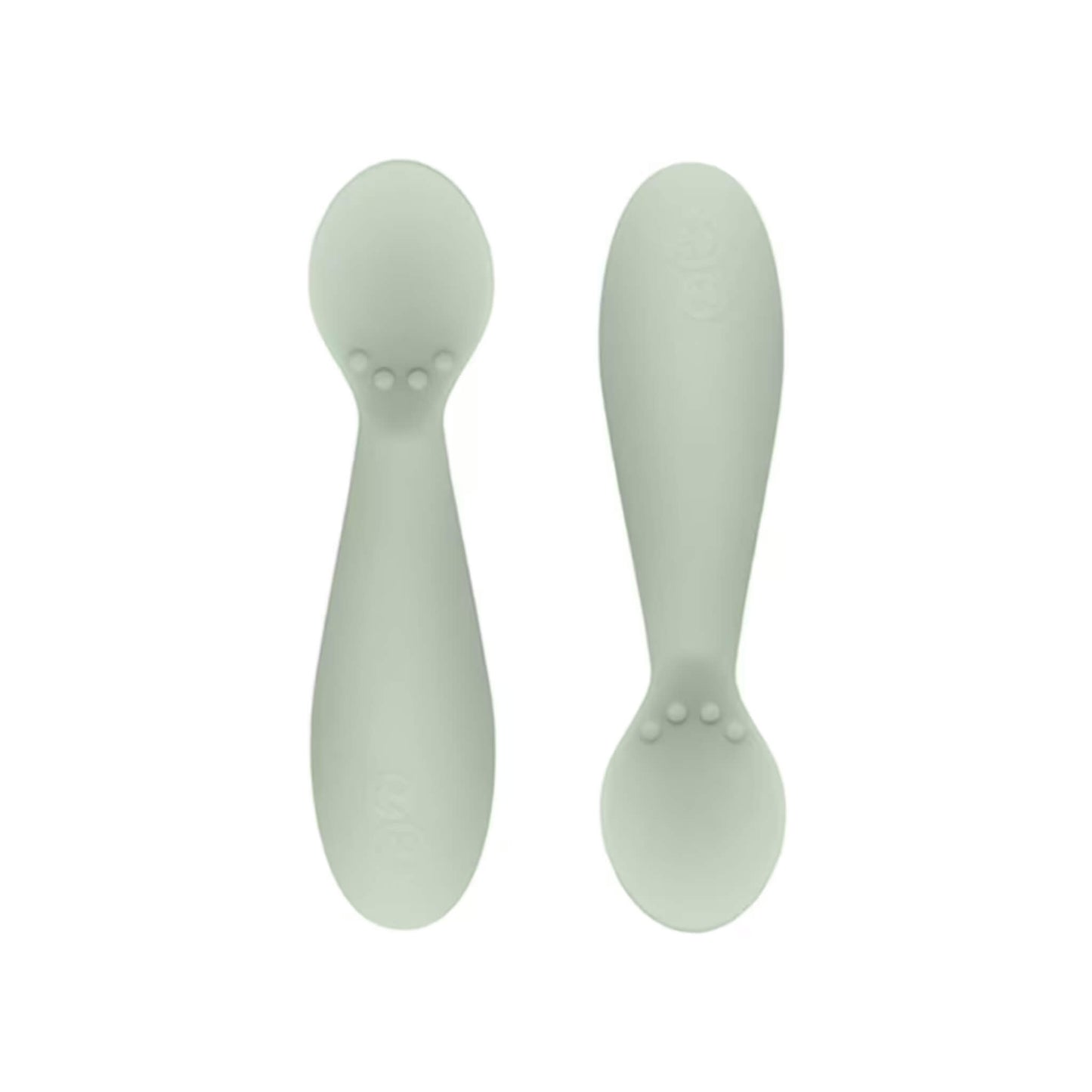 Ezpz Tiny Spoons in sage green, a pair of silicone infant training spoons with shallow heads and textured bumps near the base.