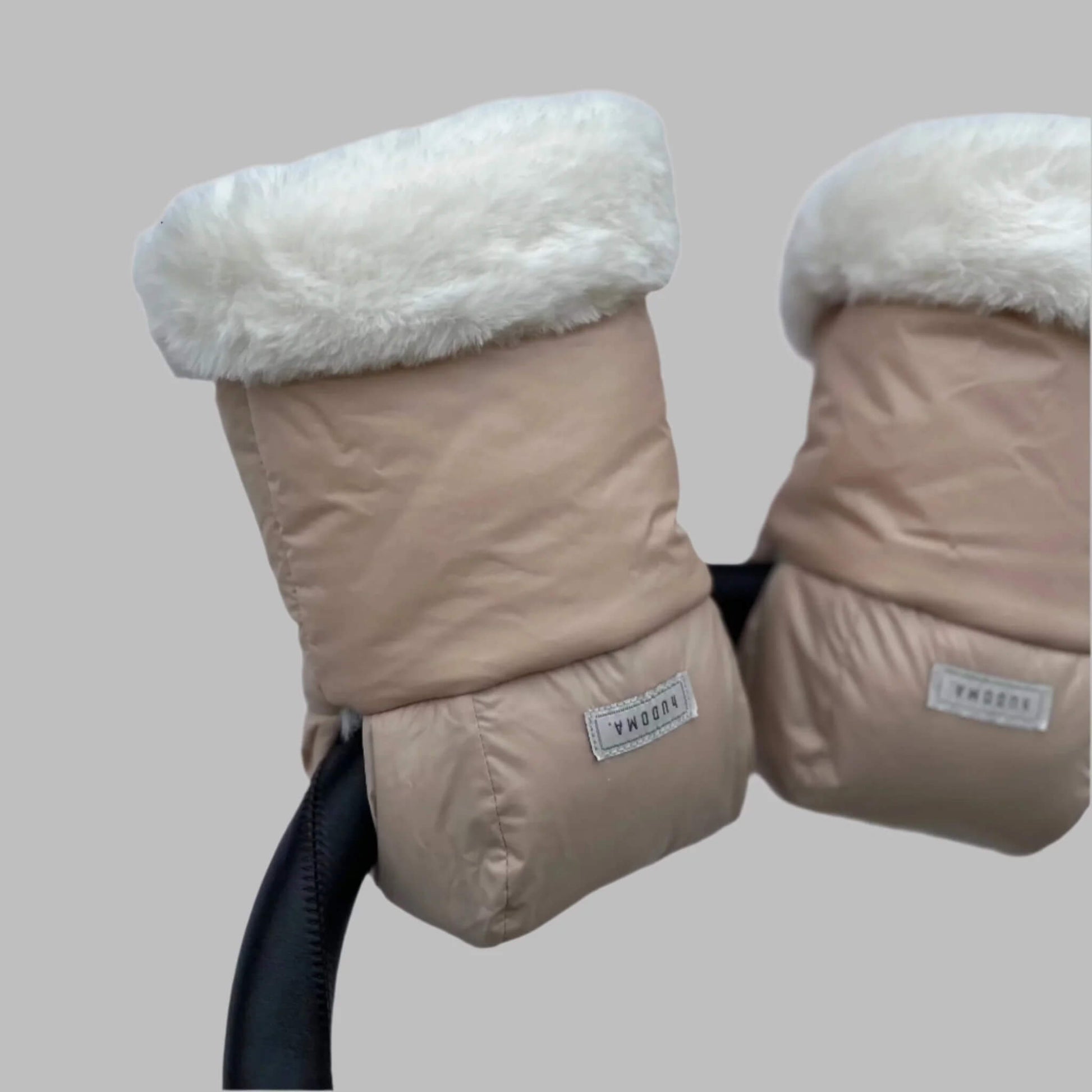 Angled view of beige pram gloves on a stroller handle, showing soft faux fur trim and smooth outer fabric.