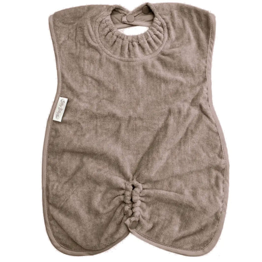 Taupe towelling highchair bib with elasticated neckline, soft absorbent fabric and gathered lower section designed to sit comfortably around a highchair tray.